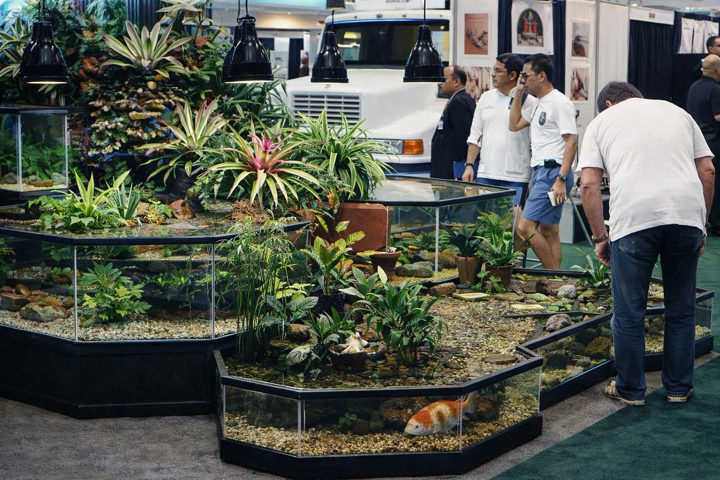 Aquarium display with plants and fish at an indoor event, people observing.
