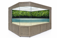 Hexagonal fish tank with wooden frame and glass sides, containing water and green plants.